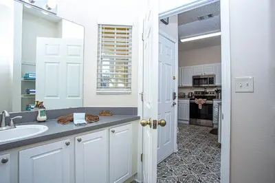 a white kitchen with a sink and a counter at Floridian at Emerald Island in Kissimmee