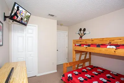 a bedroom with a bunk bed with a mickey mouse on the wall at Floridian at Emerald Island in Kissimmee