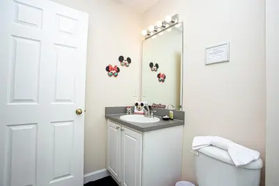 a bathroom with a sink and a toilet and a mirror at Floridian at Emerald Island in Kissimmee