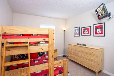 a bedroom with a wooden bunk bed and a lamp at Floridian at Emerald Island in Kissimmee
