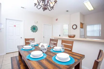 a dining room with a wooden table and chairs at Bella Vista at Emerald Island in Kissimmee