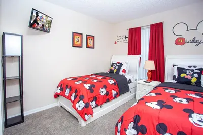 two beds in a bedroom with red comforter at Bella Vista at Emerald Island in Kissimmee