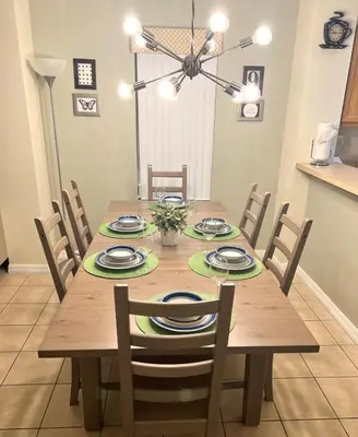 a wooden dining room table with chairs and a dining room at Meriggiare at Emerald Island in Kissimmee