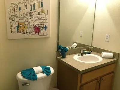 a bathroom with a toilet and a sink and a mirror at Meriggiare at Emerald Island in Kissimmee