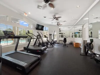 a gym with treadmills and exercise equipment in a room at Meriggiare at Emerald Island in Kissimmee