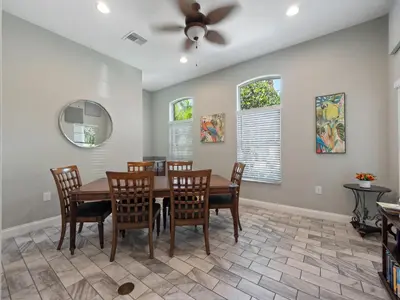 a dining room with a table and chairs and a ceiling fan at Meriggiare at Emerald Island in Kissimmee