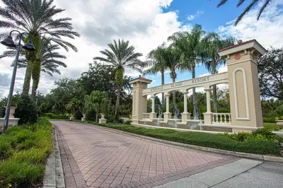 a gate in a park with palm trees at Meriggiare at Emerald Island in Kissimmee