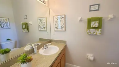 a bathroom with a sink and a mirror at Asteria at Emerald Island in Kissimmee