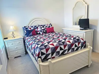 a bedroom with a bed and a mirror and a tv at La Isla at Paradise by PropertyChekker! in Kissimmee