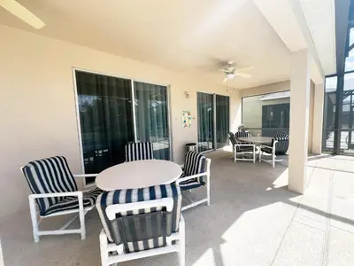a patio with a table and chairs and windows at La Isla at Paradise by PropertyChekker! in Kissimmee