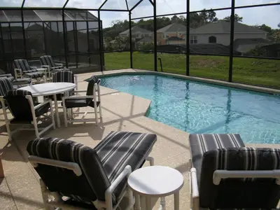a swimming pool with chairs and tables and a table and chairs at La Isla at Paradise by PropertyChekker! in Kissimmee