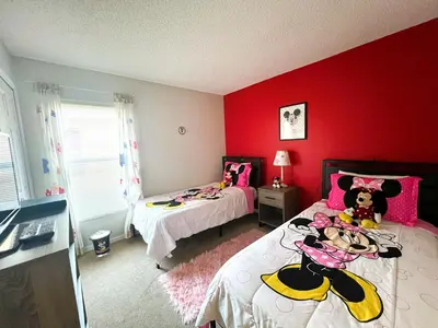 two beds in a room with red walls at The Haven in Kissimmee