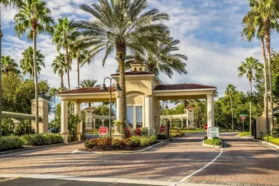 a house with palm trees in front of a road at The Haven in Kissimmee