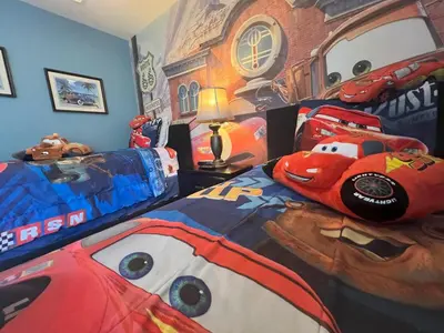 a bedroom with a bed with a disney car bedspread at Mickey's Castle by PropertyChekker! in Orlando