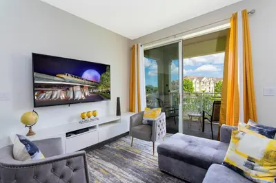 a living room with a tv and a couch at Apartamento 2 Suítes no Cane Island Resort in Kissimmee