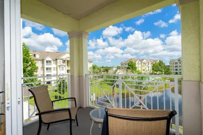 a balcony with chairs and a view of the water at Apartamento 2 Suítes no Cane Island Resort in Kissimmee
