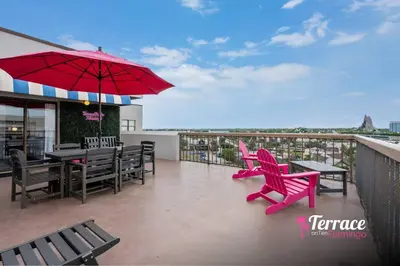 a patio with a table and chairs and an umbrella at Gorgeous 2 Bed 2 Bath Flamingo Penthouse Volcano Bay View in Orlando
