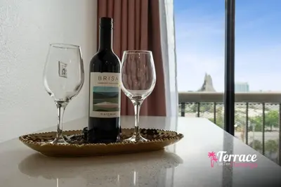 a bottle of wine and two glasses on a table at Gorgeous 2 Bed 2 Bath Flamingo Penthouse Volcano Bay View in Orlando