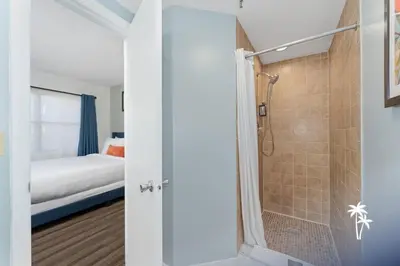 a bathroom with a shower and a bedroom at Relaxing 2 Bed 2 Bath Condo with Garden View Balcony 7 Min to Universal in Orlando