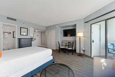 a bedroom with a large bed and a dining room at Superior Central Condo with Balcony 7 Min to Universal in Orlando