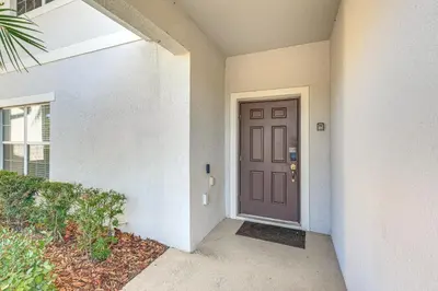 a front door of a building with a purple door at Lanai and Private Pool, 8 Mi to WDW Family Getaway! in Kissimmee