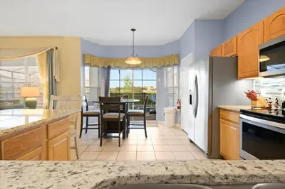 a kitchen and dining room with a table and chairs at Windsor Hills Fun 6BR Villa Pool Spa By Disney in Orlando