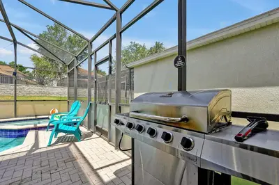 a kitchen with a grill and a swimming pool at Themed Windsor Hills 6BR Private Pool Gameroom in Orlando