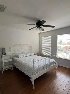 a bedroom with a bed with a ceiling fan at The Mahal in Sanford