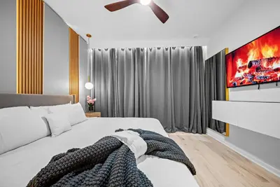 a bedroom with a white bed and a tv at Dream 8-Bedroom Home with Pool in Kissimmee