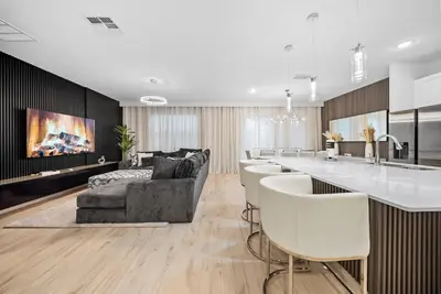 a kitchen and living room with a couch and a bar at Dream 8-Bedroom Home with Pool in Kissimmee