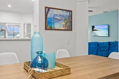 a dining room table with a blue vase and two candles at 6 BR Home, Themed Rooms, Private Pool, Windsor Hills by Blue Sky Villas in Orlando
