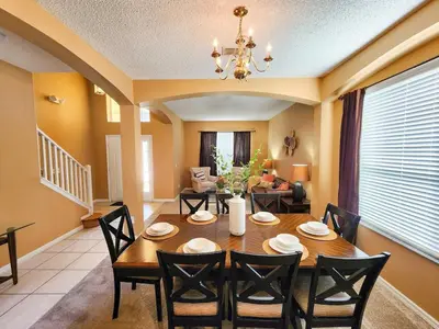 a dining room with a table and chairs at Spacious 7BR Retreat w Pool & Jacuzzi V#202 in Kissimmee