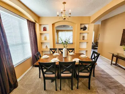 a dining room with a table and chairs at Spacious 7BR Retreat w Pool & Jacuzzi V#202 in Kissimmee