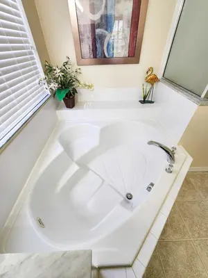 a large white tub in a bathroom with a window at Spacious 7BR Retreat w Pool & Jacuzzi V#202 in Kissimmee