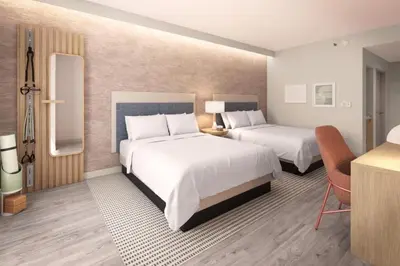 a hotel room with two beds and a desk at EVEN Hotel Orlando Universal Blvd by IHG in Orlando