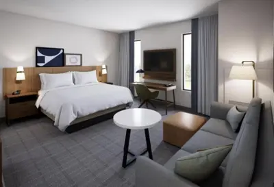 a hotel room with a bed and a couch at Staybridge Suites Orlando Universal Blvd by IHG in Orlando