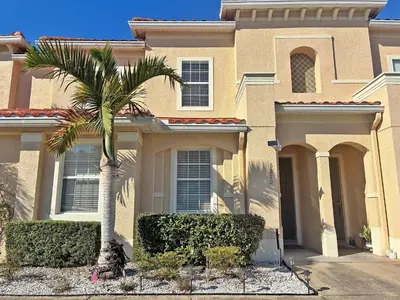 a house with a palm tree in front of it at Paradise Cay Resort - Close to Disney in Kissimmee