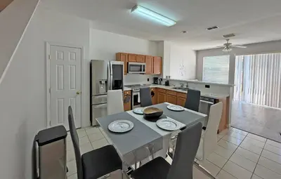 a kitchen with a table and chairs and a kitchen with at Paradise Cay Resort - Close to Disney in Kissimmee