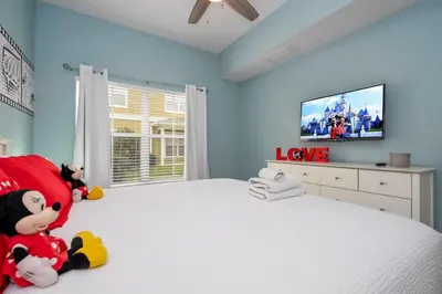 a bedroom with a large bed with a tv on it at Condo 4Q Seven Dwarfs Resort - Perto da Disney in Kissimmee