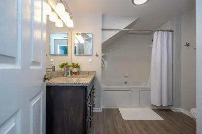 a bathroom with a sink and a tub and a shower at Condo 4Q Seven Dwarfs Resort - Perto da Disney in Kissimmee