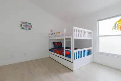 a white room with a bunk bed and a window at Resort-Style Home Near Disney | Pool | Game Room in Kissimmee