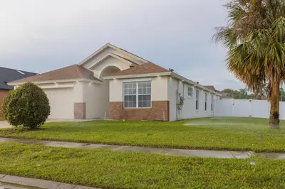 a house with a palm tree in front of it at Resort-Style Home Near Disney | Pool | Game Room in Kissimmee