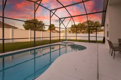 a swimming pool with a view of the sunset at Resort-Style Home Near Disney | Pool | Game Room in Kissimmee