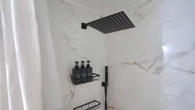 a bathroom with a shower with wine bottles on a shelf at Quiet Boho Suite near Orlando attractions in Orlando