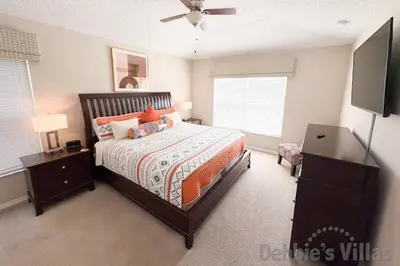 a bedroom with a bed and a flat screen tv at Seasons Kissimmee in Kissimmee