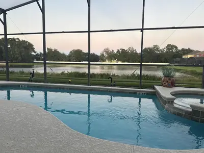 a swimming pool with a view of a lake at Seasons Kissimmee in Kissimmee