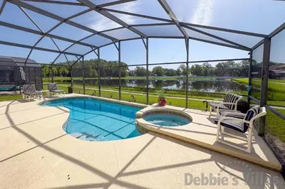 a swimming pool in a pavilion with two chairs at Seasons Kissimmee in Kissimmee