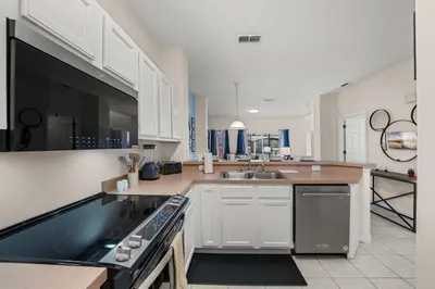 a large kitchen with white cabinets and a sink at 8564 Bay Lilly Loop in Kissimmee