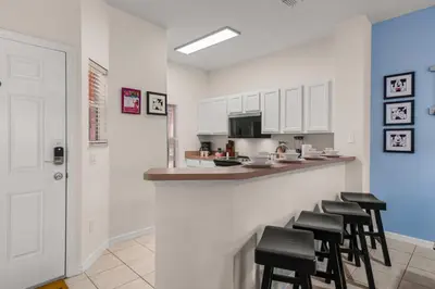 a kitchen with a bar with stools at 8564 Bay Lilly Loop in Kissimmee