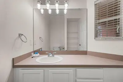a bathroom with a sink and a large mirror at 8564 Bay Lilly Loop in Kissimmee